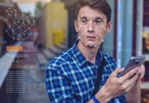 UK Digital ID Backlash Explodes Young man using a smartphone with face recognition overlay