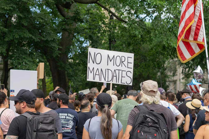 202226174 Crowd holds No More Mandates sign at protest.
