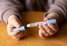 Why The VA Fine Print Blocks Ozempic Hands holding an Ozempic injection pen.