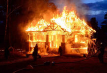 Holiday Fun Turns Homicide House engulfed in flames with firefighters present.