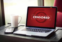 Hidden Censorship Network Exposed Laptop screen displaying CENSORED beside coffee and phone