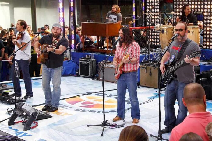 A band performing live on stage with an audience in front