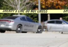 Dental X-Ray Room Horror Exposed Sheriff's line tape blocking a street with police cars behind