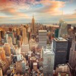 Aerial view of New York City skyline during sunset with skyscrapers and clouds
