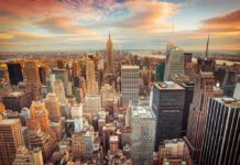 Drones Swarm Empire State Building — See Why Aerial view of New York City skyline during sunset with skyscrapers and clouds