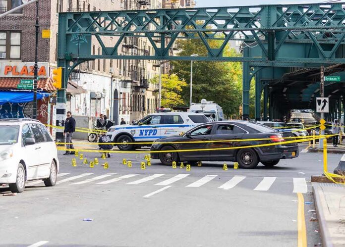 Police cars block a city intersection with yellow crime scene tape