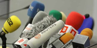 Roach Crash-Lands On Live TV A collection of various microphones arranged for a press conference