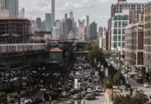 City street with heavy traffic and elevated subway tracks