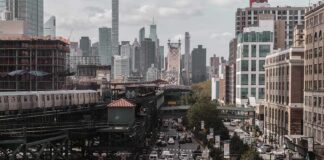 City street with heavy traffic and elevated subway tracks