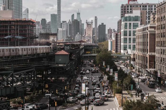 shutterstock_1103255165 City street with heavy traffic and elevated subway tracks