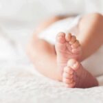 baby feet on a soft white blanket
