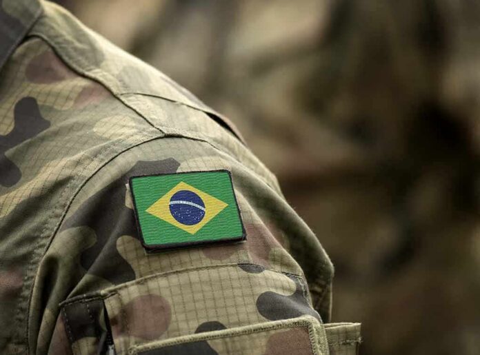 shutterstock_1522957613 Brazil flag patch on a camouflage military uniform sleeve