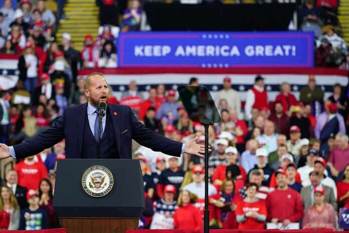Speaker at podium addressing large crowd at political rally