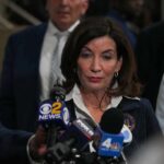 Woman speaking to reporters at a press scrum