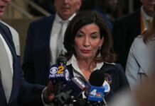 Woman speaking to reporters at a press scrum