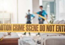 crime scene tape in a living room with two officers in background