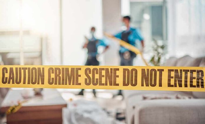 crime scene tape in a living room with two officers in background
