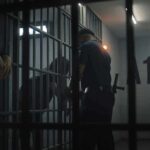Ghanaian Migrant Arrested 4 Times in 2 Weeks for Sex Crimes police officer at a jail cell with detainees behind bars