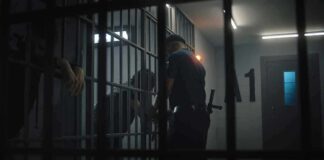police officer at a jail cell with detainees behind bars
