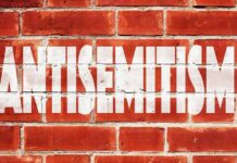 Hate-Filled Vandal Slipped Through NYC’s Cracks Before Jewish Mother Was Killed Brick wall with large white stencil text