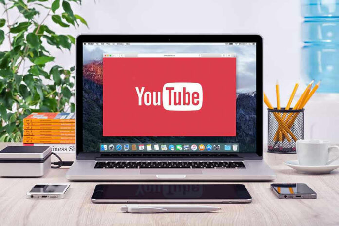 293731811-1 YouTube logo on a laptop screen on desk.