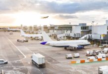 FAA Power Grab Sparks National Showdown Airplanes at airport gates during sunset with ground vehicles and jet bridges