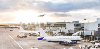 FAA Power Grab Sparks National Showdown Airplanes at airport gates during sunset with ground vehicles and jet bridges