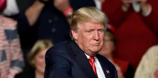 Trump Says ‘America Will Never Be a Communist Country’ man in suit pointing toward the camera at an event