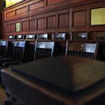 A Black Juror Held the Line and They’re Coming for Him Empty wooden jury box with numbered chairs
