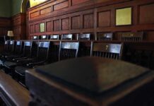 Empty wooden jury box with numbered chairs