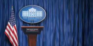 Why The WHPress Corps Should Stop Whining About Access and Start Reporting White House press briefing podium with U.S. flag and blue curtain