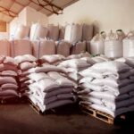 Stacked white sacks on pallets in a warehouse