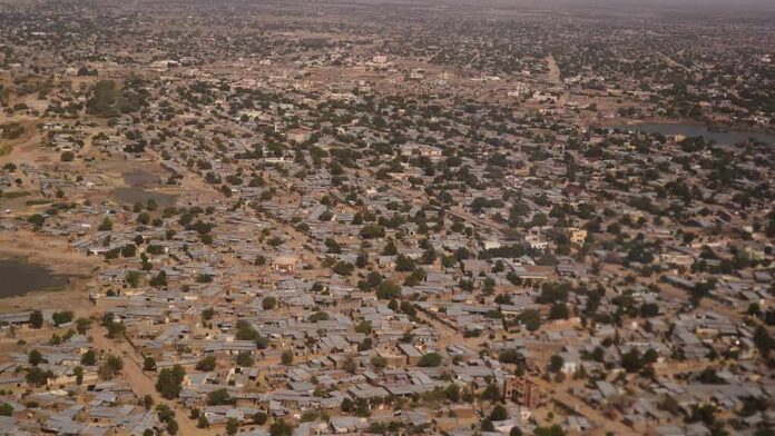 Aerial view of sprawling city with low-rise buildings and scattered trees