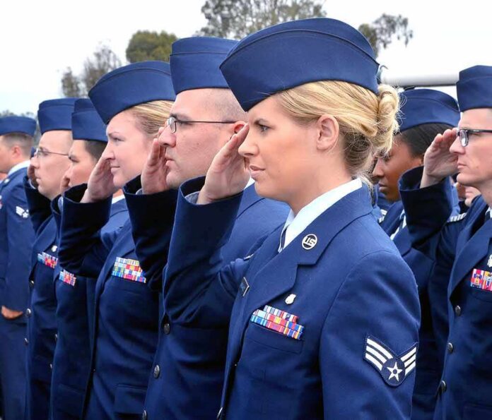 Uniformed service members saluting in formation