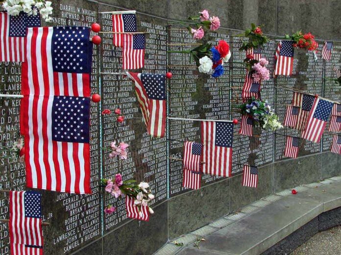 Memorial wall adorned with American flags and flowers