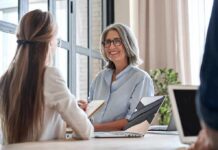 Smiling woman with gray hair talking in a modern office