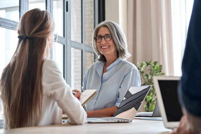 Smiling woman with gray hair talking in a modern office