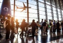 Gunshots Trigger PANIC at Major U.S. Airport Passengers queue inside an airport terminal at sunset