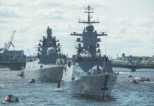 Two modern naval warships anchored on a river