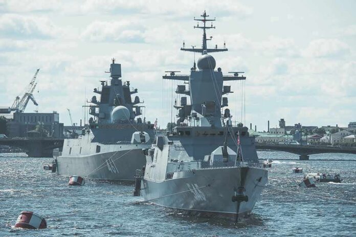 shutterstock_2103481931 Two modern naval warships anchored on a river