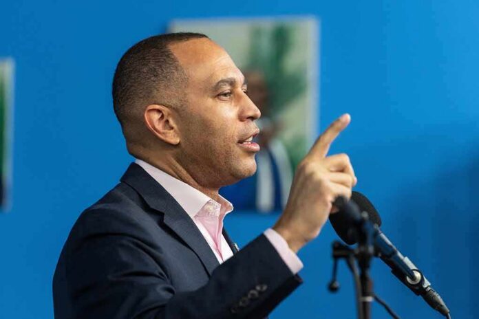 Man speaking at a microphone with raised finger