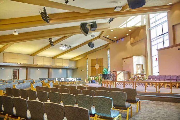 Empty church sanctuary with rows of chairs facing a stage