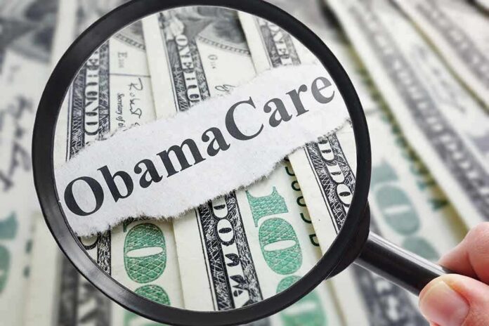 Magnifying glass over cash highlighting Obamacare text