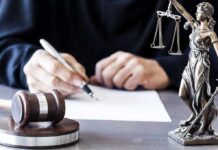 Is Lindsay Clancy Debate the Result of Decades of Abortion Rhetoric? Judge writing at desk with gavel and Lady Justice statue