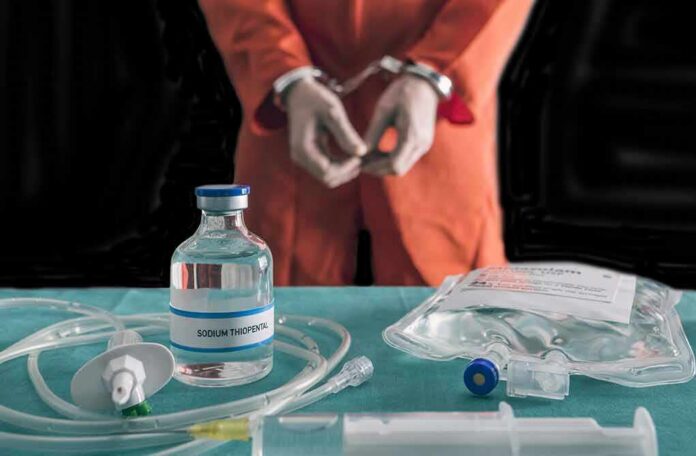 shutterstock_762356716 Handcuffed person in orange jumpsuit behind medical vials and IV equipment