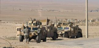 U.S. Troops Were Moved to a More Exposed Position Soldiers near armored vehicles in a desert