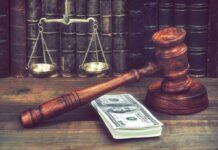 Epstein’s Inner Circle Just Got SUED Judge's gavel beside cash and scales of justice on a wooden desk
