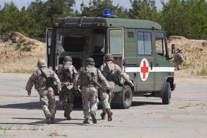 shutterstock_105071369-2 Soldiers running towards a medical vehicle during a military operation
