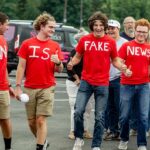 Group of young people in red shirts walking and giving thumbs up