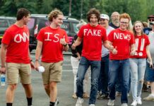 Group of young people in red shirts walking and giving thumbs up